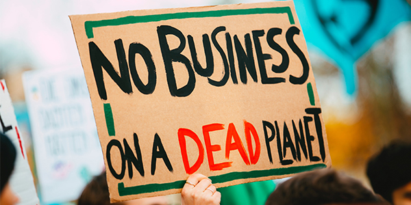 Placard with the words no business on a dead planet